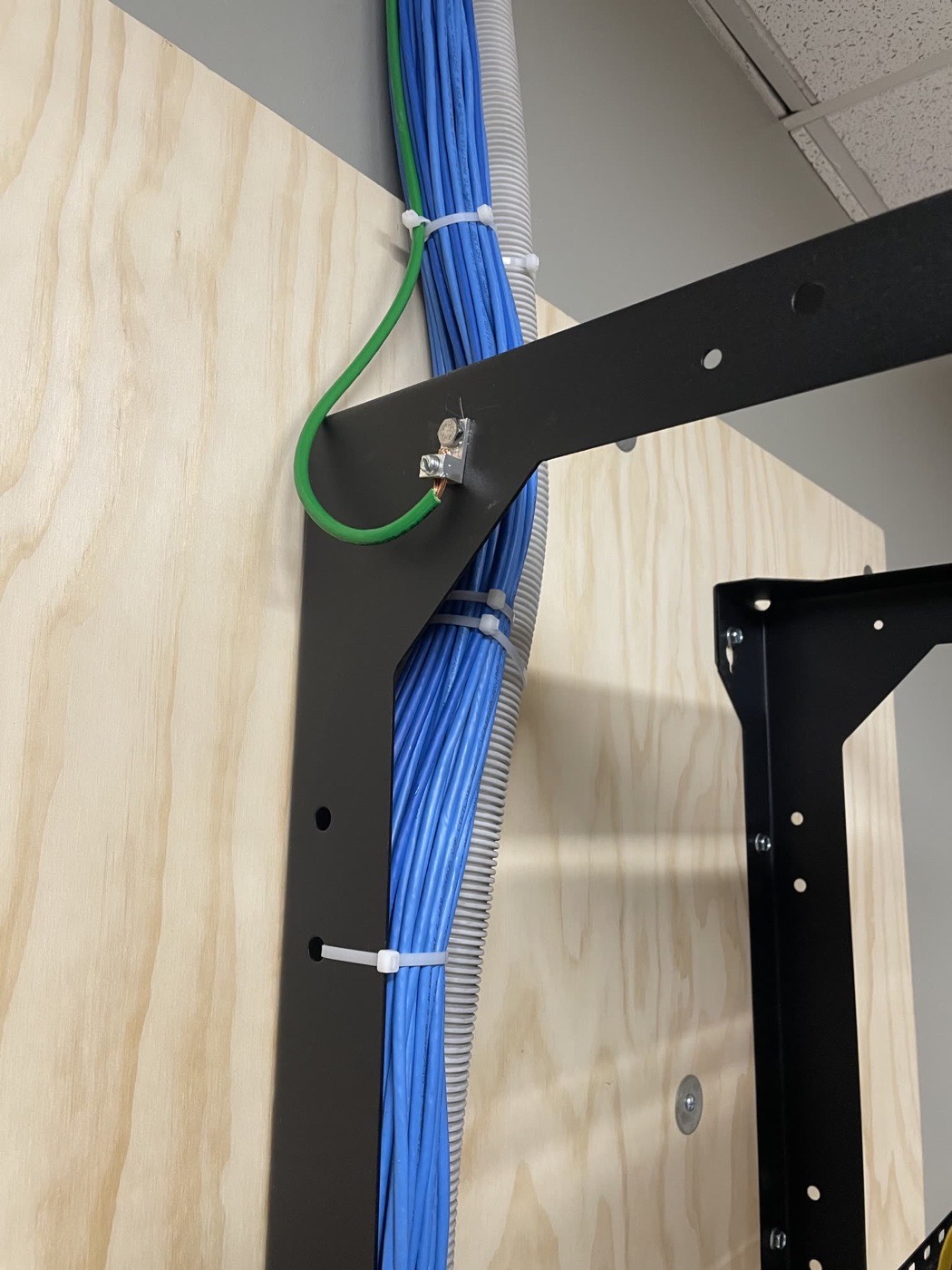 Rack grounding lug with bonded ground wire and loomed cable bundles